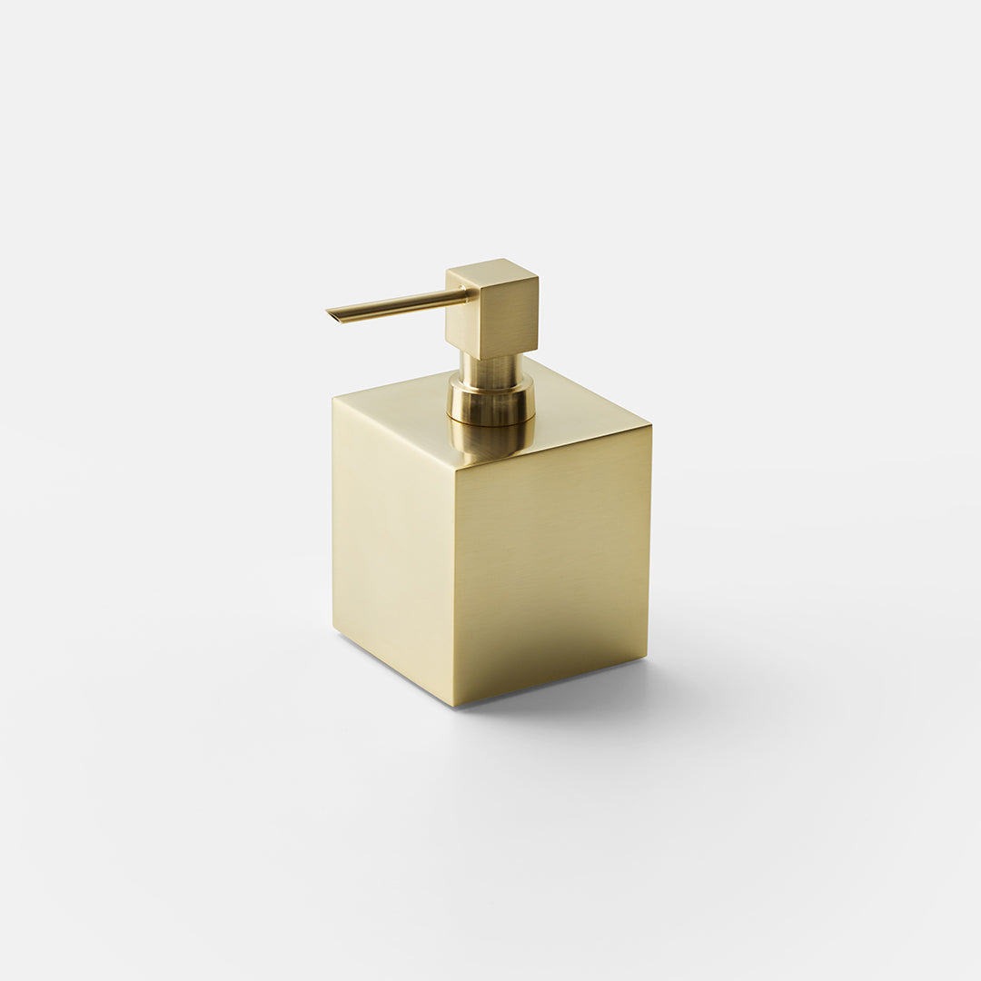Freistehender quadratischer Seifenspender DW475 aus matt vergoldetem massivem Messing in 24-Karat-Optik mit 400 ml Inhalt vor neutralem Hintergrund.