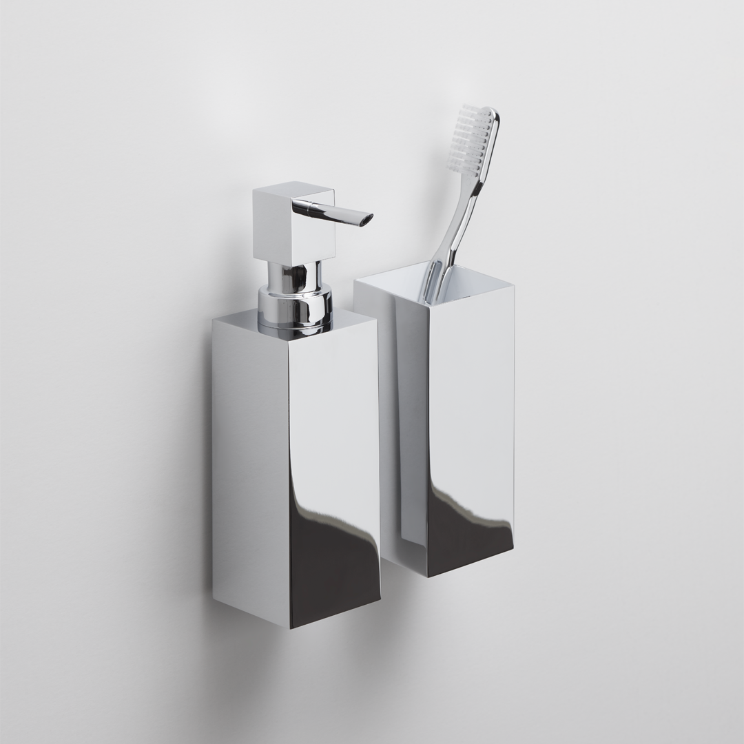 Hochwertiges Wandset von Decor Walther in Chrom mit Seifenspender und passendem Zahnputzbecher in perspektivischer Ansicht.