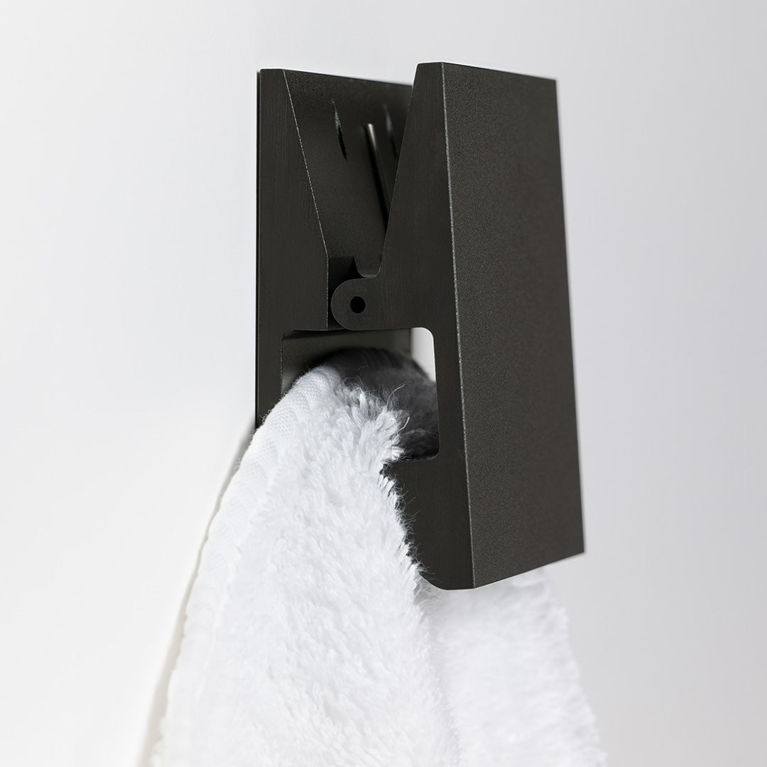 Stilvoller Haken in Schwarz matt, selbstklebend oder verschraubt montierbar, ideal für Badtextilien und Accessoires.