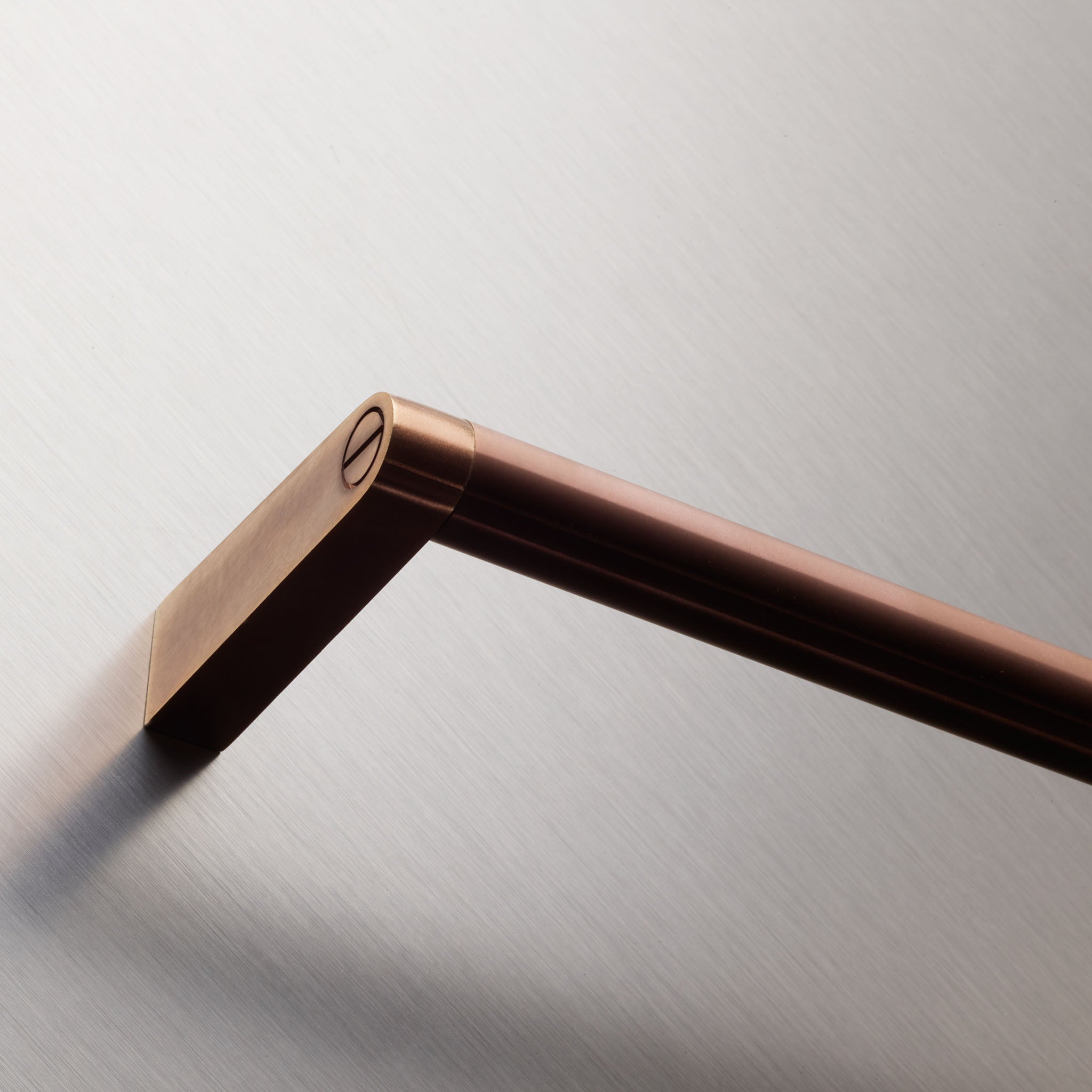 Detailaufnahme der Decor-Walther SOHO HTE Handtuchstange aus massivem Messing in Kupfer matt PVD mit markanten Schraubdetails und hochwertiger Oberflächenveredelung