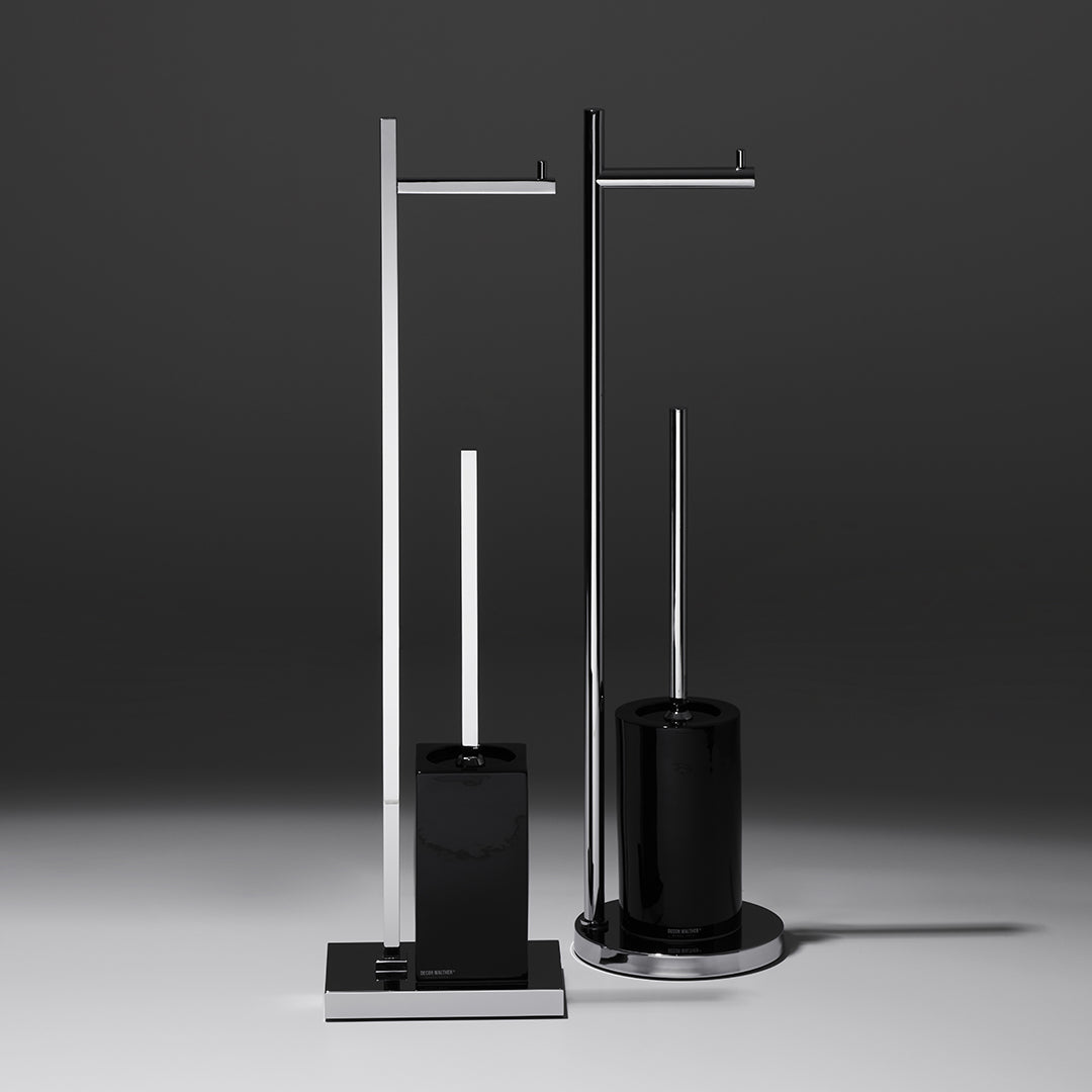 Freistehende WC-Bürstengarnituren von Decor Walther: Modell DW6700 mit runder Form und Modell DW6710 mit eckigem Design, beide in Schwarz mit Chromdetails und integrierter Papierhalterung.