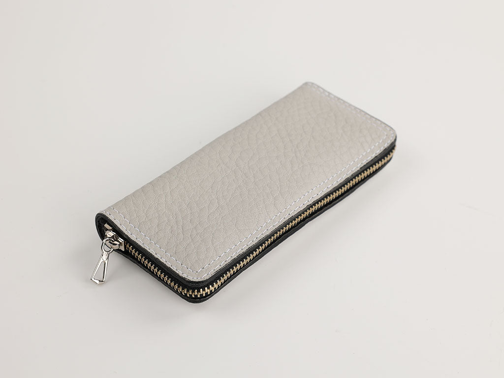 Ein geschlossenes graues Maniküre-Etui mit Reißverschluss, in einer kompakten und eleganten Ausführung, ideal für die Reise oder den täglichen Gebrauch.