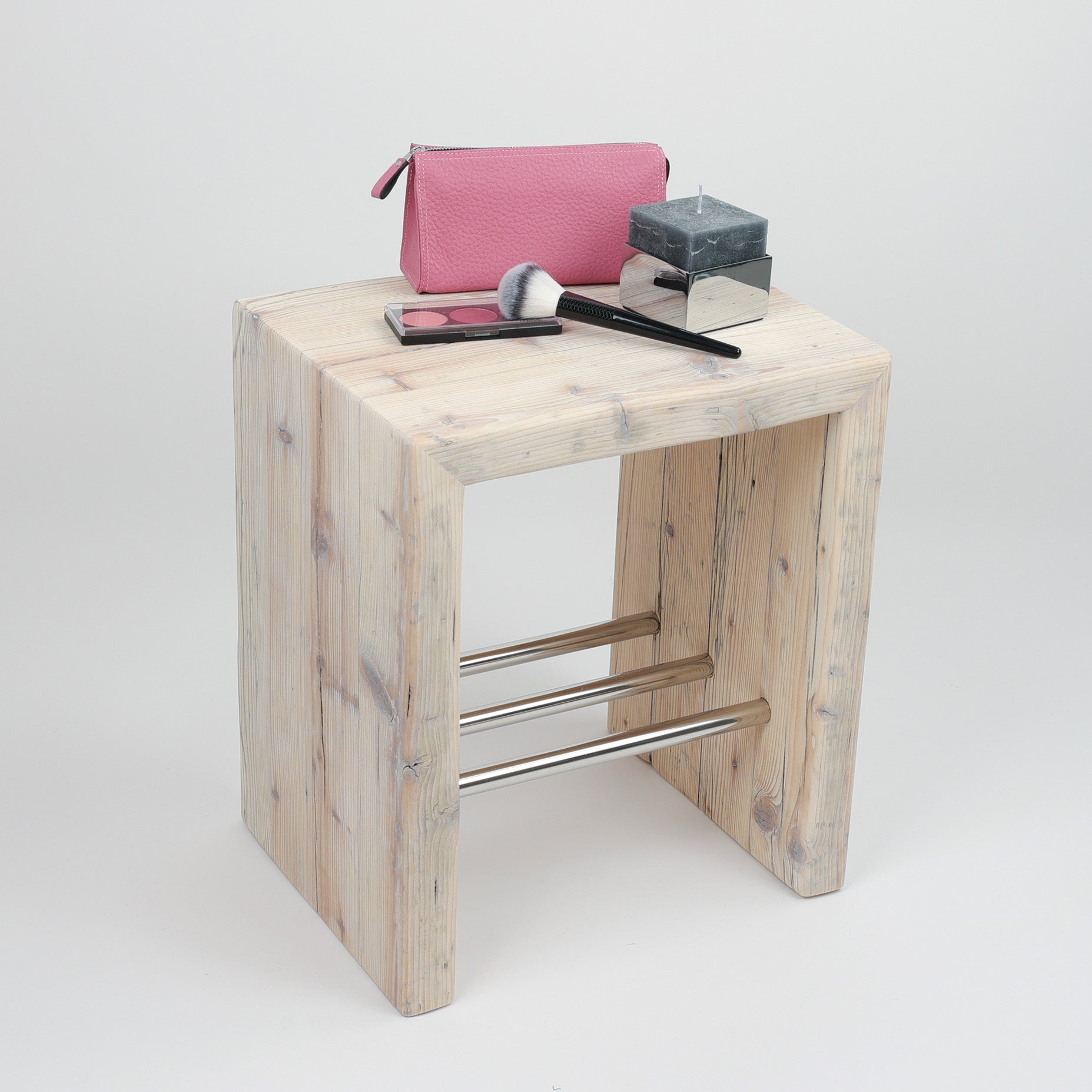 Badhocker Altholz, drapiert mit Kulturtasche in pink von Hammann und Kerze von Decor Walther