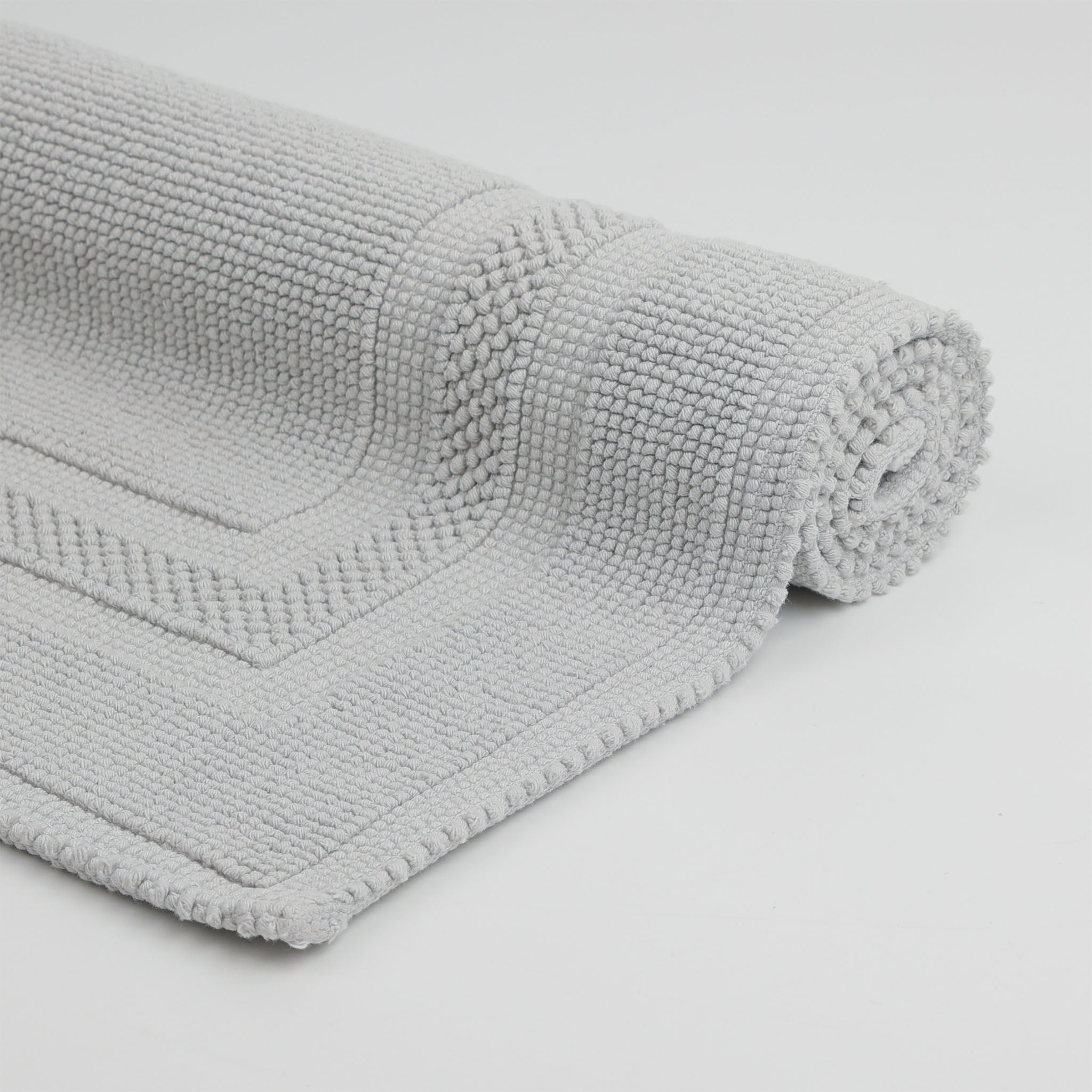 Aufgerollter Rhomtuft Badteppich GALA aus 100 % gewebter Baumwolle in puristischem Design mit abgesetztem Rahmen, Farbe Perlgrau – hochwertig, langlebig und pflegeleicht