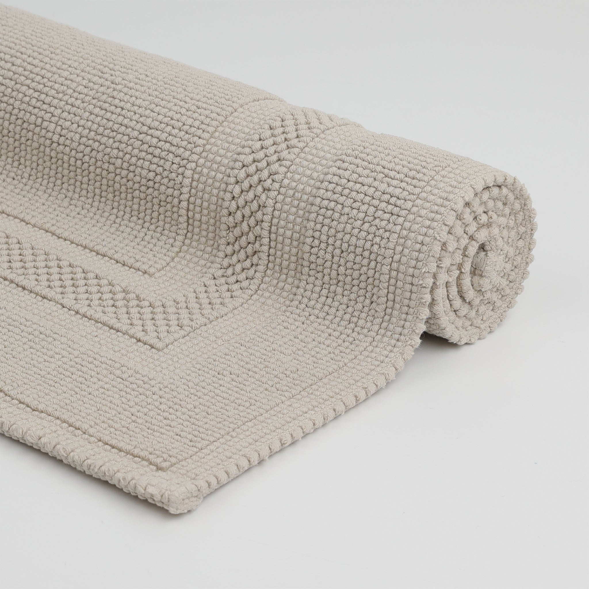 Aufgerollter Rhomtuft Badteppich GALA aus 100 % gewebter Baumwolle in puristischem Design mit abgesetztem Rahmen – hochwertig, langlebig und pflegeleicht