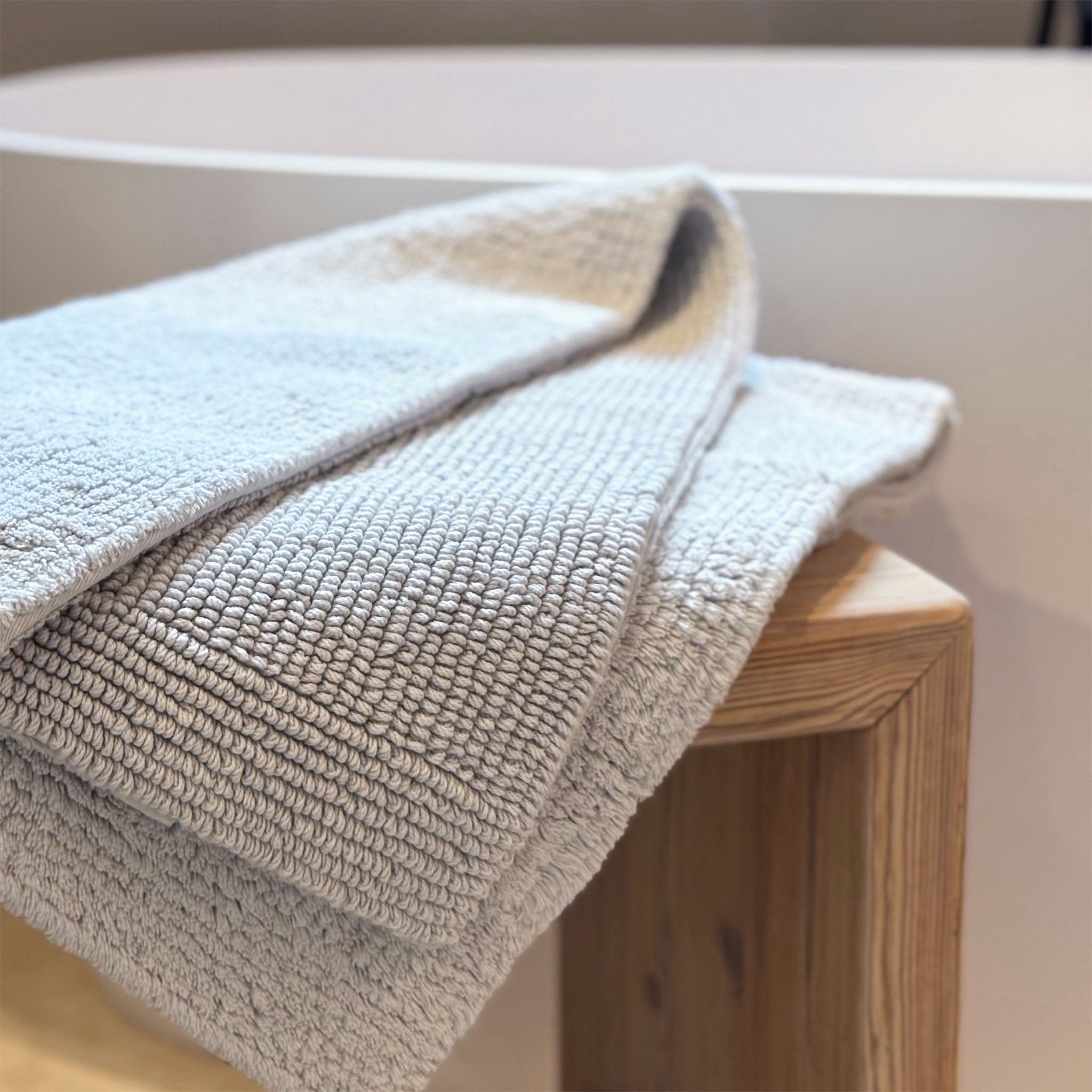 Perlgrauer Badteppich auf Hocker-Rhomtuft Pur-traumhaft weich-langlebiger Wendeteppich-Beste Baumwollqualität