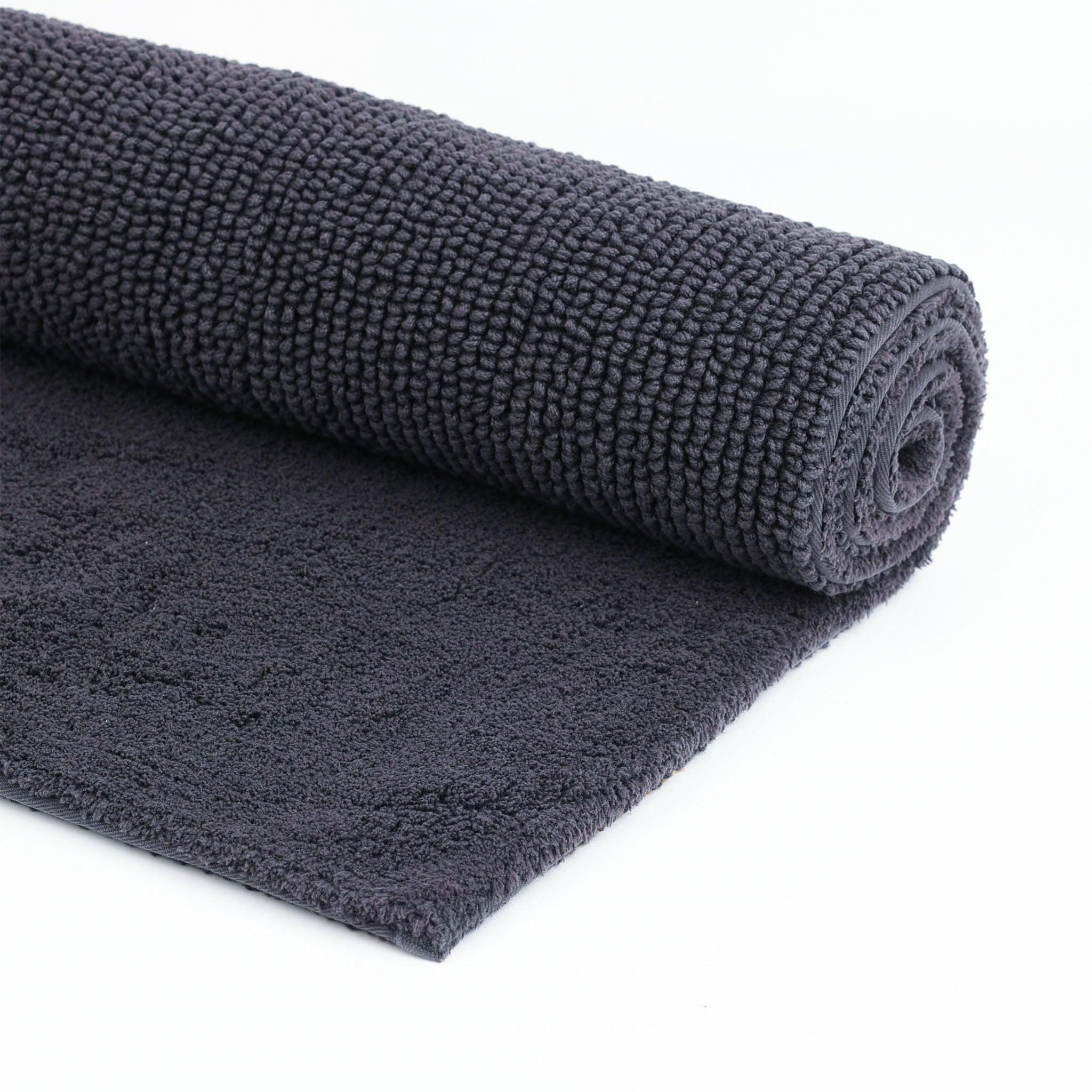 Zusammengerollter Badteppich in Zinn–weiche Baumwolle–Serie Pur von Rhomtuft–zweiseitige Nutzung–dezente Eleganz im Bad
