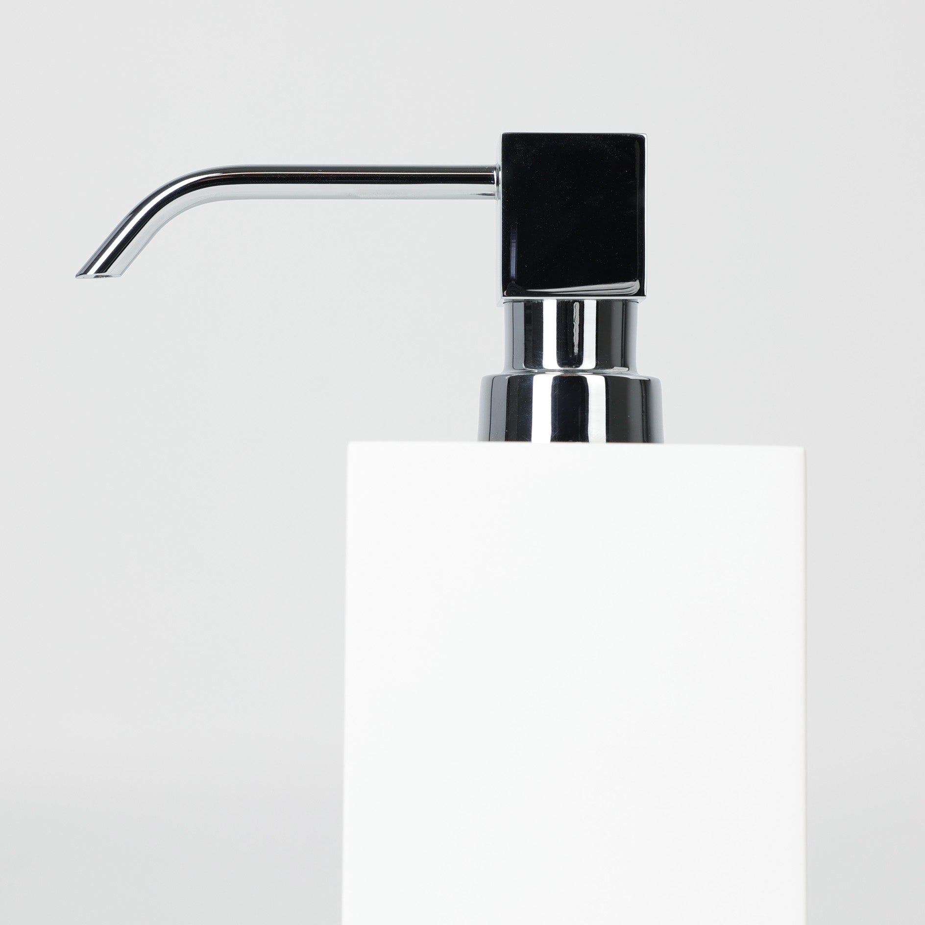 Verchromter Pumpenkopf aus Messing in Würfelform auf weißem Seifenspender aus Corian, Detailansicht, hergestellt von dasfeinebad