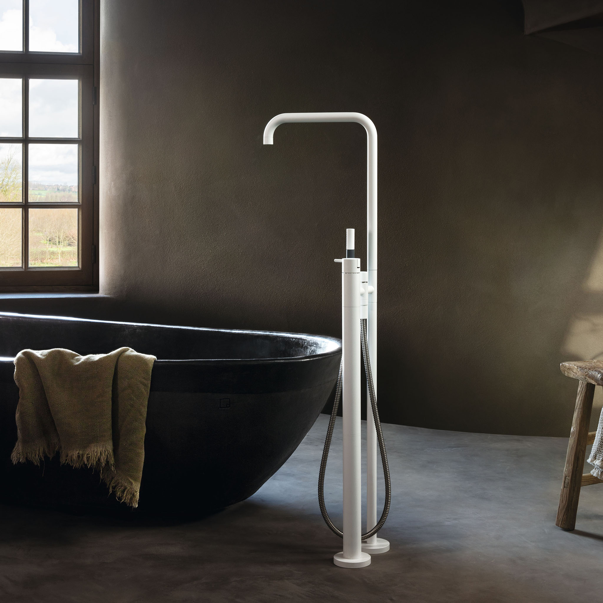 Vola FS1 freistehende Badewannenarmatur in Weiß matt mit integriertem Handbrausemodul.