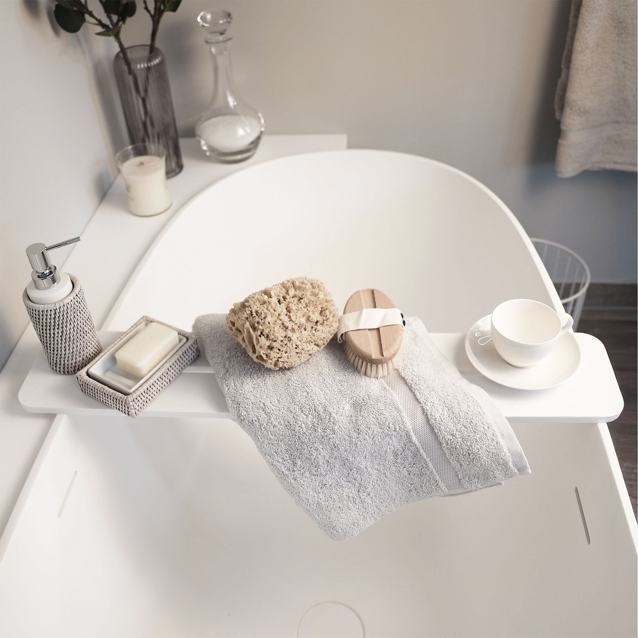 Badewannentablett aus weiß-mattem Corian® mit mittiger Ablaufrinne – handgefertigt in Hamburg von dasfeinebad - dekoriert mit Seifenspender und Seifenschale Basket von Decor Walther
