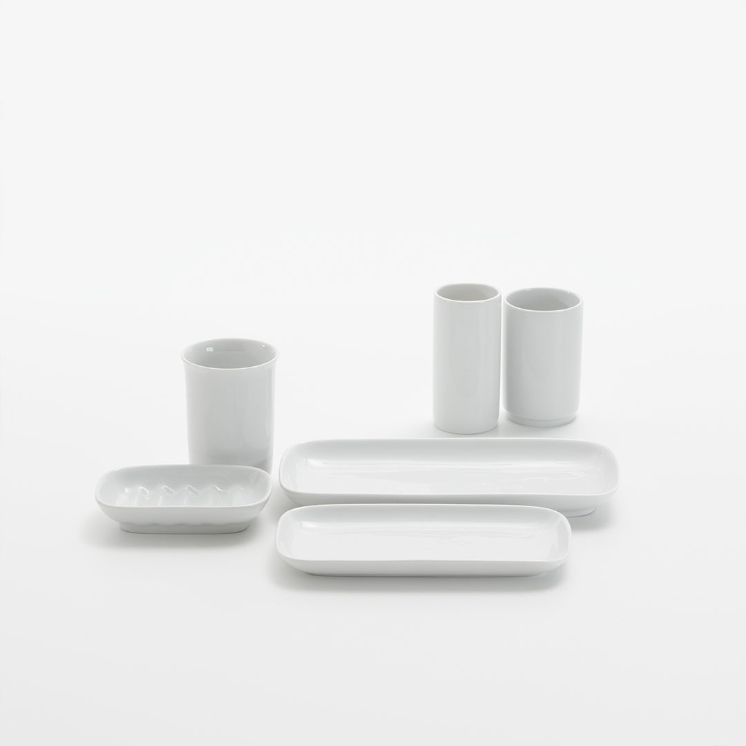 Komplettes Badzubehör-Set aus weißem Porzellan, inklusive Zahnputzbecher, Mundbecher, Zahnputzglas, und mehr, für einheitliches Design im Badezimmer, verfügbar bei Das Feine Bad.