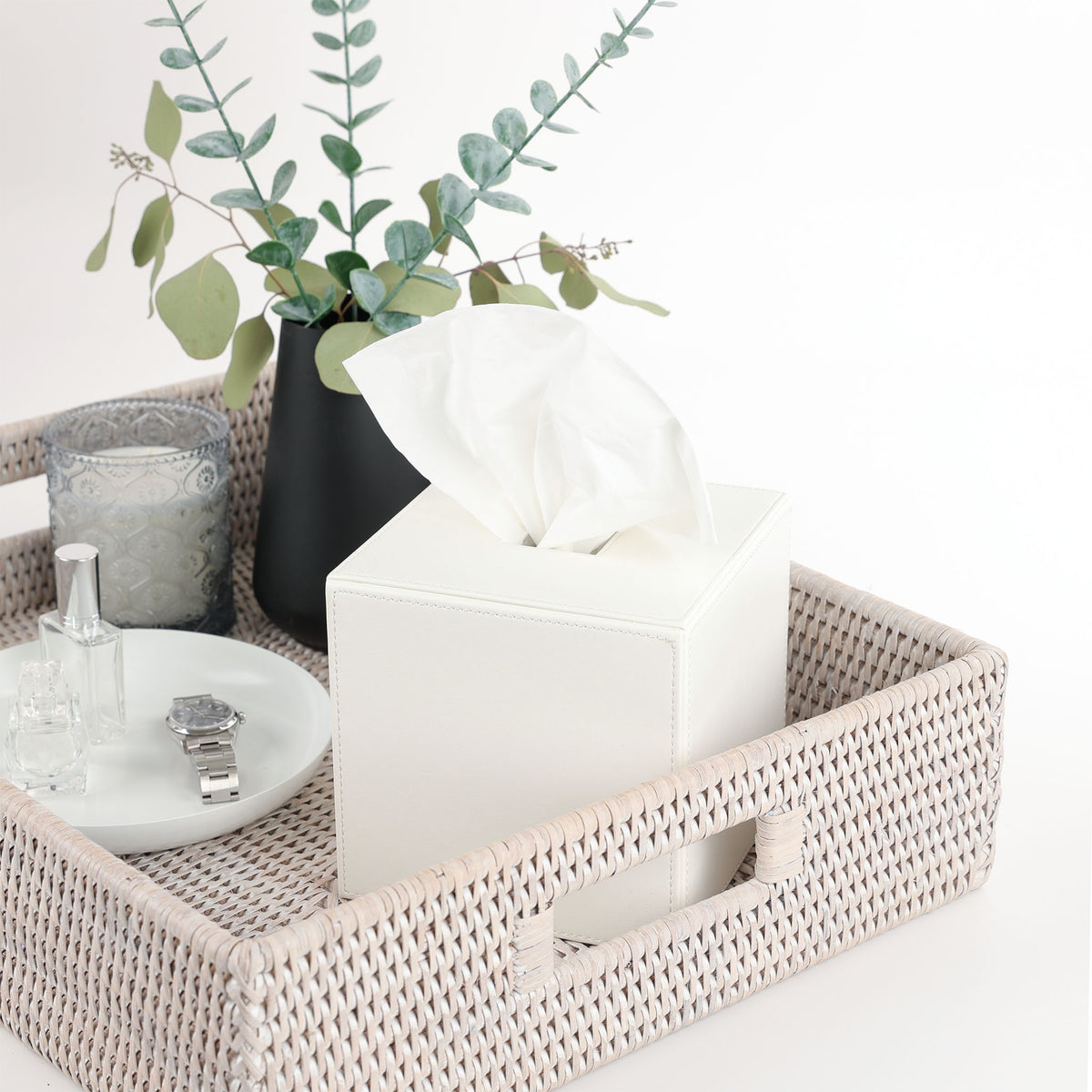 Weiße Kosmetiktuchbox von Decor Walther Brownie KB 41, quadratische Kunstlederbox, eleganter Blickfang nicht nur im Bad, dekoriert auf einem Tablett der Serie Rattan Basket mit Vase und Schale Rondo von Frost Denmark