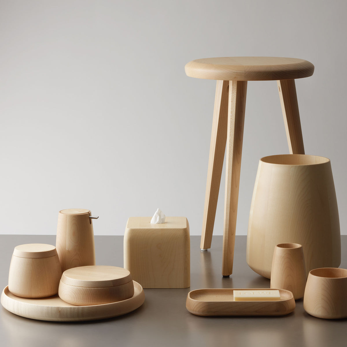 Holzhocker Decor Walther ONYO STOOL aus natürlichem Ahornholz, arrangiert mit passenden Badaccessoires wie Seifenspender, Aufbewahrungsdosen, Holztablett und Vase